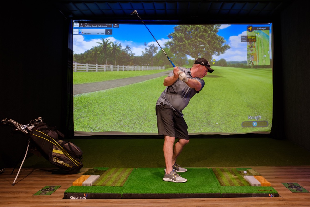 Golfer using a simulator bay at Next Level Golf